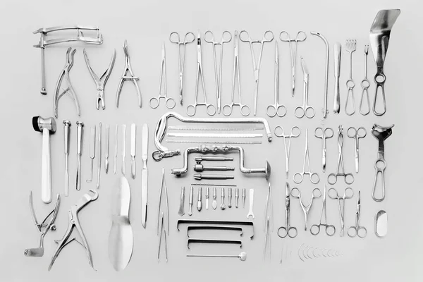 Instrumentos médicos utilizados para operaciones quirúrgicas, dispuestos sobre un fondo gris —  Fotos de Stock