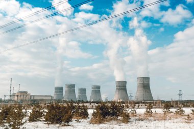 Bulutlu mavi gökyüzüne karşı altı biton nükleer enerji santrali..