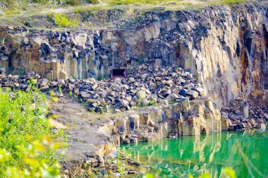 Bazalt gölünün kayaları ve sütunlarıyla bir manzara. Ukrayna. Mavi gökyüzünün arka planında.