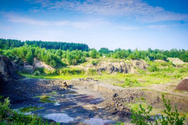 Bazalt taşı ve traktör Ukrayna 'nın çıkarılması için taş ocağı. Mavi gökyüzünün arka planında.