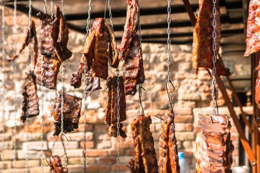 Zincire asılı tütsülenmiş et. Izgara, barbekü. Hobi olarak yemek pişirmek. Profesyonel aşçılık..