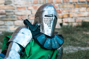 Medieval knight in armor. Green clothes. clipart