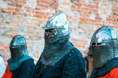 Zırhlı üç ortaçağ şövalyesi. Taklit, askeri operasyonların restorasyonu, kavgalar.