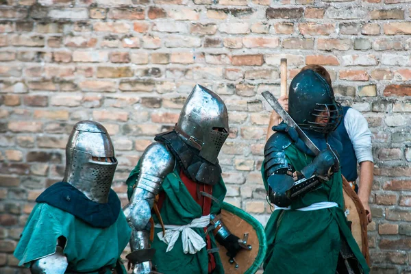 Three medieval knights in armor. The historical restoration of military events.