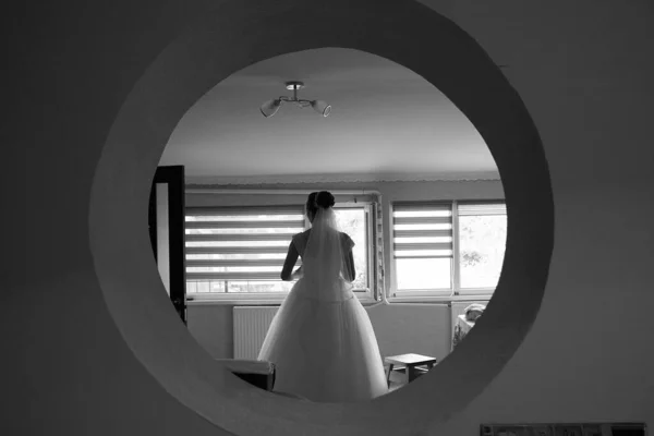 Sposa Piedi Una Finestra Rotonda Con Schiena Bianco Nero Prepararsi — Foto Stock