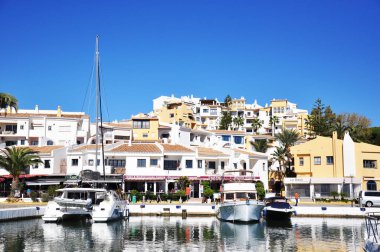 Beyaz ve sarı evlere karşı birkaç yatı olan Marina.