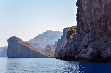 Mavi gökyüzüne karşı geniş sarp kayalıkları olan Mallorca kıyıları