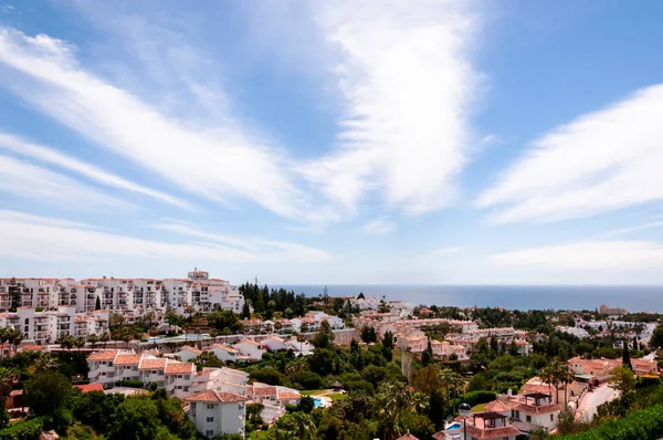 İspanyol sahil şehrinin panoramik manzarası, deniz ve gökyüzünde hafif tüy bulutları