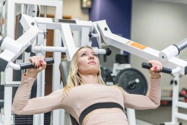 Spor salonunda spor yapan güzel kız. Kaporta işi ve aktif hayat. Spor kızı motive ve kendinden emin..