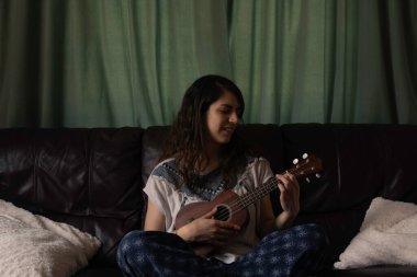 Ukrayna çalan çapraz bacaklı kadın oturma odasının koçunda oturuyor.