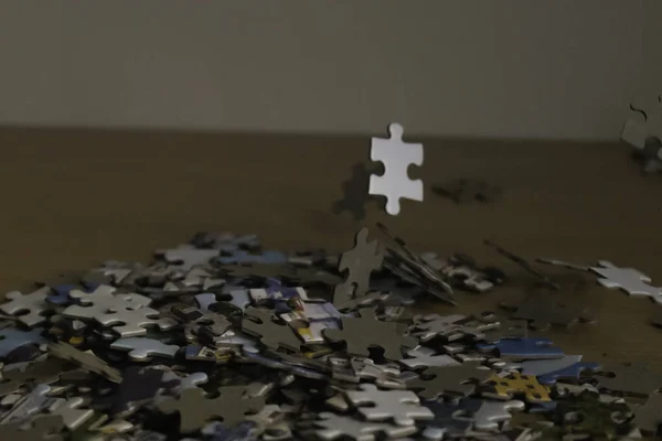 Puzzelstukjes Beukend Een Houten Tafel Met Een Witte Achtergrond — Stockfoto