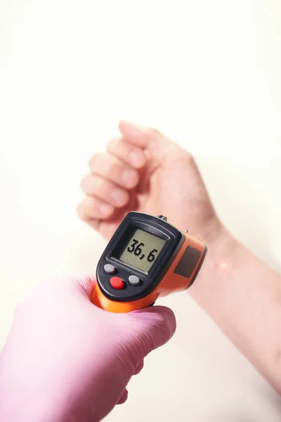 Handen i rosa handske håller ir termometer normal temperatur — Stockfoto