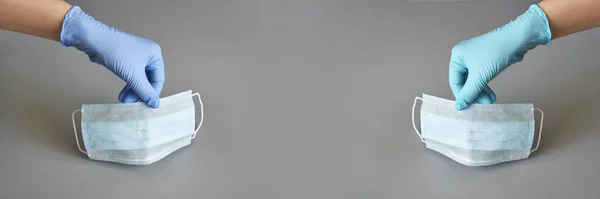 Koruyucu virüs maskesi tutan iki el. Sağlık hizmetleri temiz