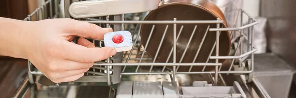 Bulaşık makinesinin arka planında el deterjanı var.