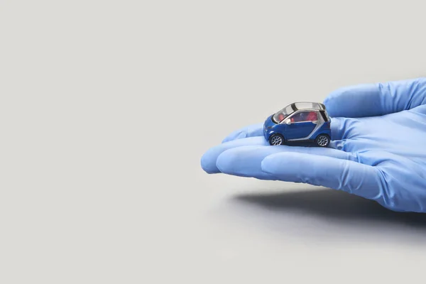 Hand i handske försvara leksaksbil. Begreppet säkerhetsförsäkring — Stockfoto