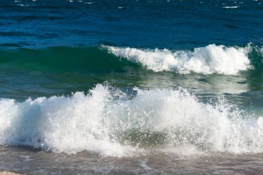 Rüzgarlı günlerde, Garda Gölü 'nün suyu sahile ulaşır ve çakıl taşı plajında kırılıp gerilen köpüklü ve parlak dalgalar oluşturur. Sonbaharda suyun çok koyu mavi bir rengi vardır. İtalya.