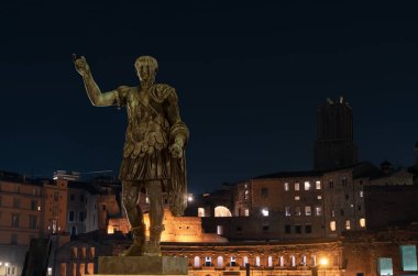 Trajan Heykeli, İmparatorluk Forumları, Roma. İspanya doğumlu Roma İmparatoru. Reformlarıyla, su kemerleri ve limanlarda inşaat işleriyle meşhurdur. Trajan pazarlarındaki Trajan köşesinde hikayesini anlatıyor..