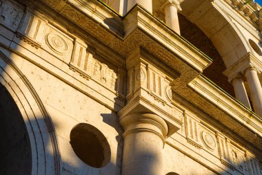 Bazilika Palladiana 'nın dekorasyonunun detaylarıyla dolu bir yakın plan. Sıcak öğleden sonra ışığı. Kemerler, Yunan tarzı başkentler, triglifler ve köfteler, sütunlar. İtalya.