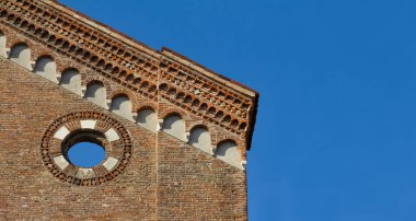 San Lorenzo di Vicenza kilisesinin Gotik görünüşünün ayrıntıları. Ortaçağ binası tuğla kullanır. Ayrıntılar gökyüzünde dairesel bir deliği ve süslemeyi temsil ediyor. İtalya.