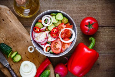 Domates salatası salatalık soğan turp avokado biberi ahşap arka planda