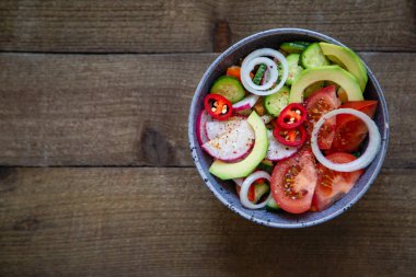 Domates salatası salatalık soğan turp avokado biberi ahşap arka planda