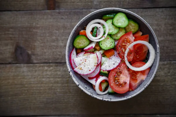 Domates salatası salatalık soğan turp avokado biberi ahşap arka planda