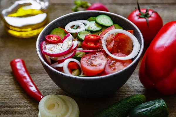 Domates salatası salatalık soğan turp avokado biberi ahşap arka planda