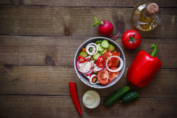 Domates salatası salatalık soğan turp avokado biberi ahşap arka planda