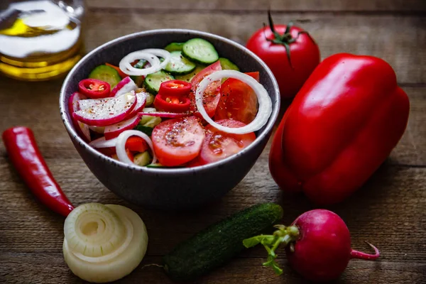 Domates salatası salatalık soğan turp avokado biberi ahşap arka planda