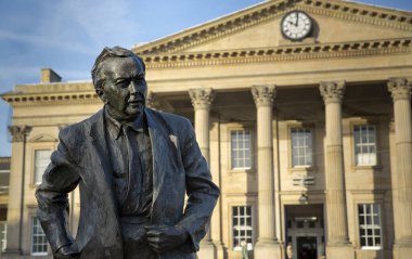 Eski Başbakan ve Açık Üniversite 'nin kurucusu Harold Wilson' ın heykeli. 13 Kasım 2013 'te doğduğu kasaba olan Huddersfield Tren İstasyonu' nun dışında yer alan İşçi Partisi Politikacısı