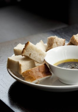 Balzamik sirke ve zeytinyağı karışımı beyaz ve kabuklu ekmeğin karışımı bir kafede hazırlanıyor.