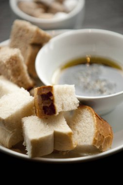 Balzamik sirke ve zeytinyağı karışımı beyaz ve kabuklu ekmeğin karışımı bir kafede hazırlanıyor.