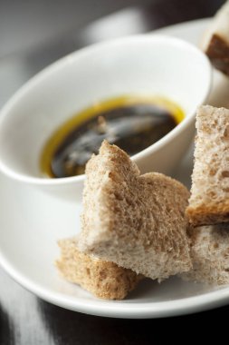 Balzamik sirke ve zeytinyağı karışımı beyaz ve kabuklu ekmeğin karışımı bir kafede hazırlanıyor.