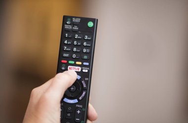 Üzerinde Netflix logosu olan uzaktan kumanda kullanan bir kişi - Şubat 2018