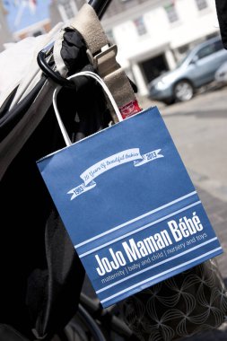 JoJo Mama Bebe alışveriş çantası St. Peter Port, Guernsey, İngiltere 'nin Kanal Adaları' nın sokaklarında bir sandalyede asılı duruyordu. 11 Temmuz 2013