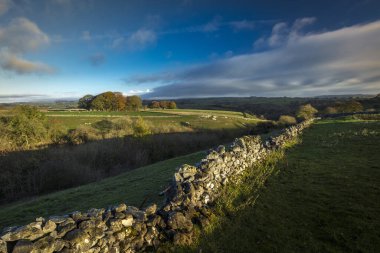 Dawn, Buxton yakınlarındaki Derbyshire, İngiltere 'deki Peak District Ulusal Parkı' nda Millers Dale ve Chee Dale 'i çevreleyen tepelere bakıyor.