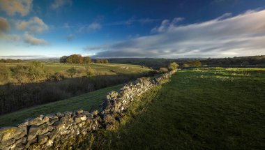 Dawn, Buxton yakınlarındaki Derbyshire, İngiltere 'deki Peak District Ulusal Parkı' nda Millers Dale ve Chee Dale 'i çevreleyen tepelere bakıyor.