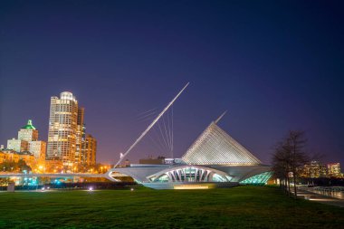 Milwaukee silueti alacakaranlıkta Michigan Gölü ve rıhtımında şehir yansıması ile.