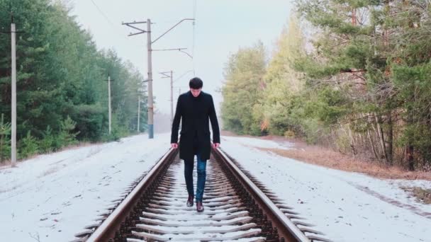 Metraje Del Joven Guapo Caminando Por Los Rieles Bosque — Vídeo de stock