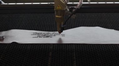 Lazer makinesinin yakın çekim görüntüleri. Deri kağıda kutsal İncil 'den bir alıntı.