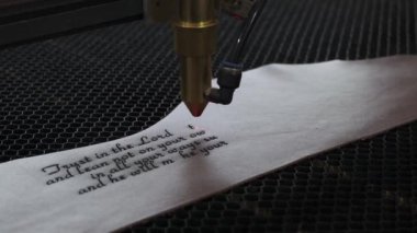 Lazer makinesinin yakın çekim görüntüleri. Deri kağıda kutsal İncil 'den bir alıntı.