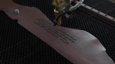 Lazer makinesinin yakın çekim görüntüleri. Deri kağıda kutsal İncil 'den bir alıntı.