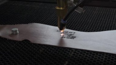Lazer makinesinin yakın çekim görüntüleri. Deri kağıda kutsal İncil 'den bir alıntı.
