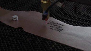 Lazer makinesinin yakın çekim görüntüleri. Deri kağıda kutsal İncil 'den bir alıntı.