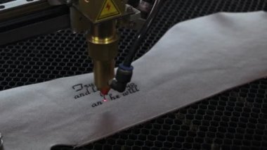 Lazer makinesinin yakın çekim görüntüleri. Deri kağıda kutsal İncil 'den bir alıntı.