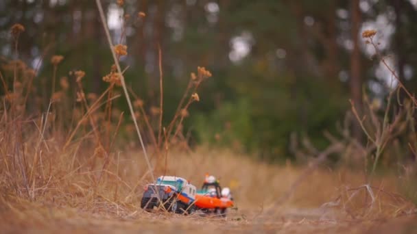 秋の公園の黄金の草の上のコンストラクタのおもちゃのクローズアップ映像 — ストック動画