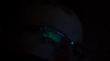 Gözlüklü adamın bilgisayar ekranına baktığı yakın çekim görüntüleri.