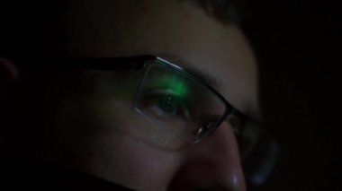 Gözlüklü adamın bilgisayar ekranına baktığı yakın çekim görüntüleri.