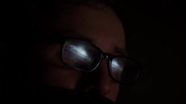 Gözlüklü adamın bilgisayar ekranına baktığı yakın çekim görüntüleri.