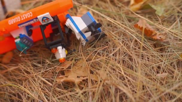 秋の公園の黄金の草の上のコンストラクタのおもちゃのクローズアップ映像 — ストック動画